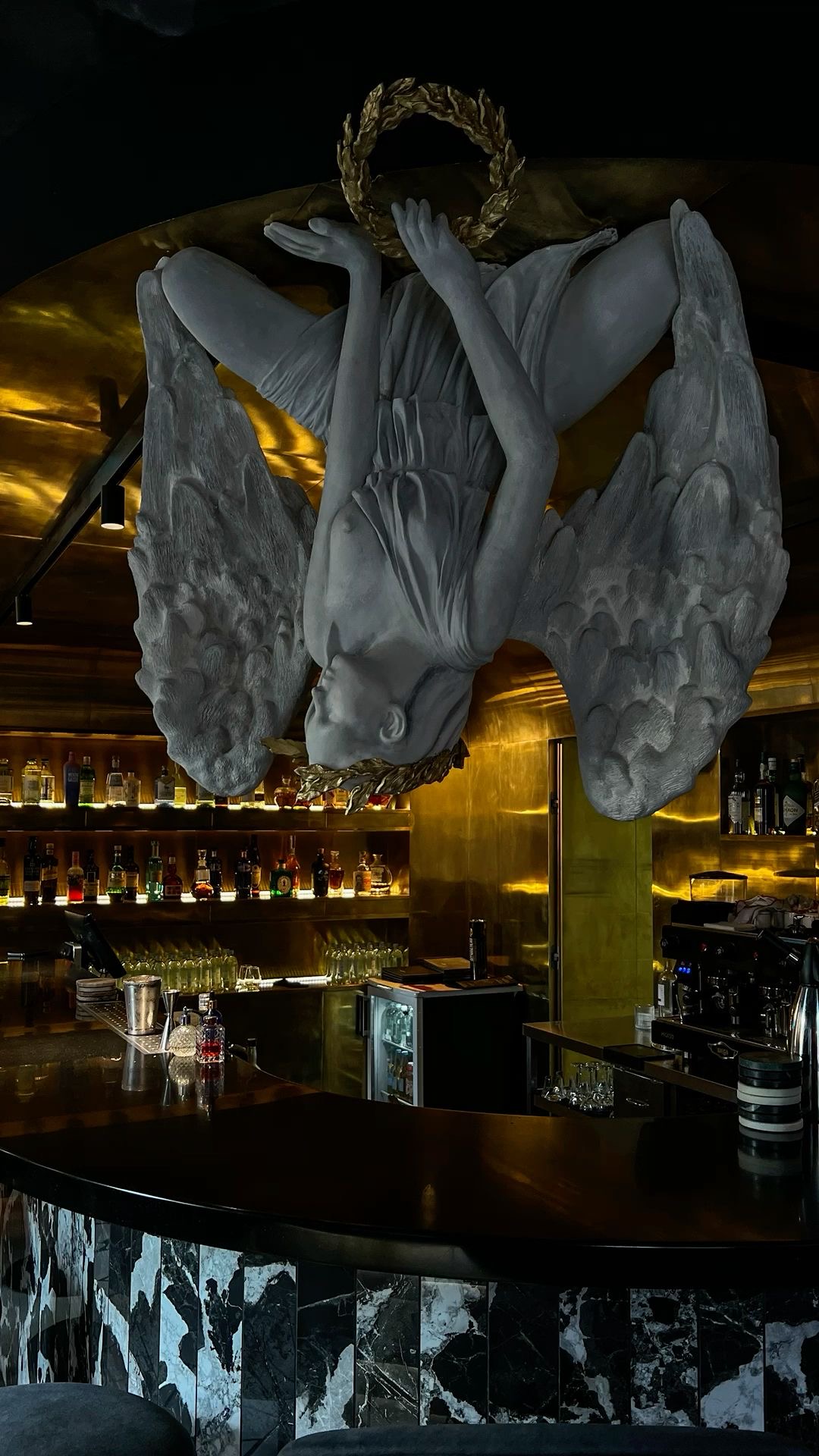 A marble angel above a golden bar